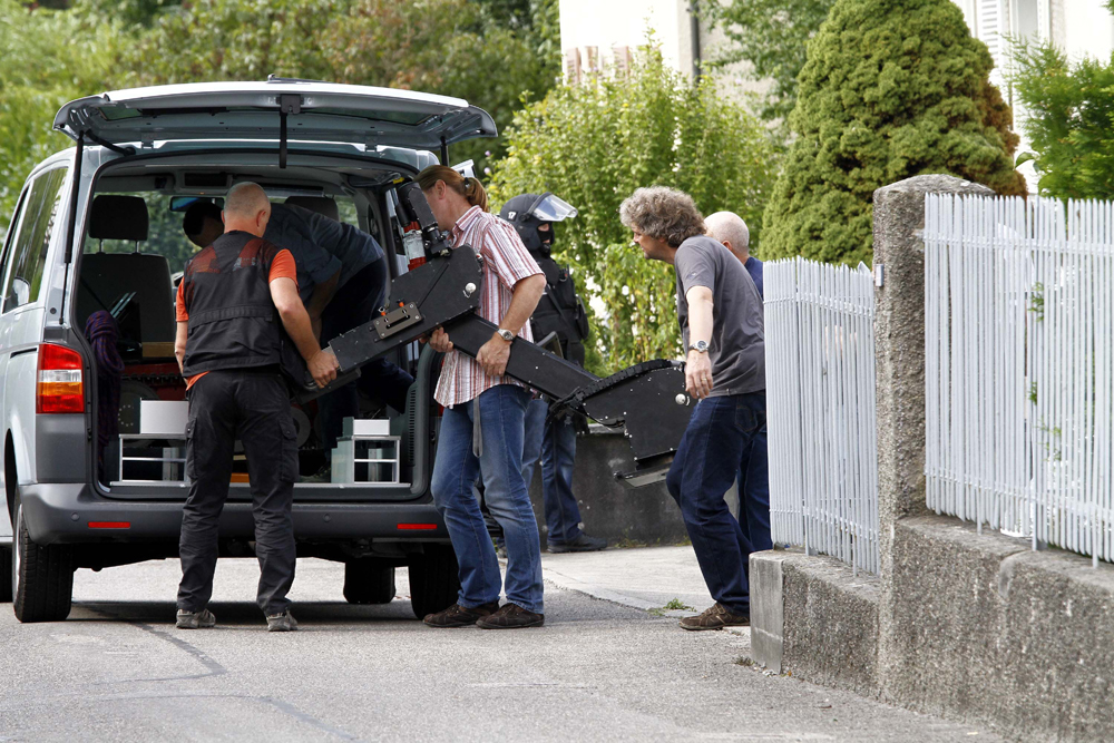 FOTO: PETER GERBER, 13.09.2010, Biel (BE):
Vor dem Haus vom Amok Opa Peter Hans trgt die Spurensicherung schweres Gert aus dem Haus, beschtzt werden sie bei dieser Arbeit von einer Sondereinheit. Auch ein kleines Raupenfahrzeug sowie Kletterseile trugen die Beamten aus dem Haus. Amok in Biel