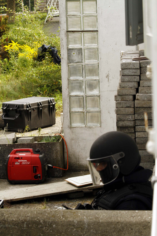 FOTO: PETER GERBER, 14.09.2010, Biel (BE):
Der Kriminaltechnische Dienst der Polizei bereitet im Garten des Amok Hausen von Peter Hans alles vor um Vermessungen des Gartens vorzunehmen. Die Kriminaltechniker werden von der Elitepolizei beschtzt. Nebst der Vermessung wird auch untersucht woher geschossen wurde