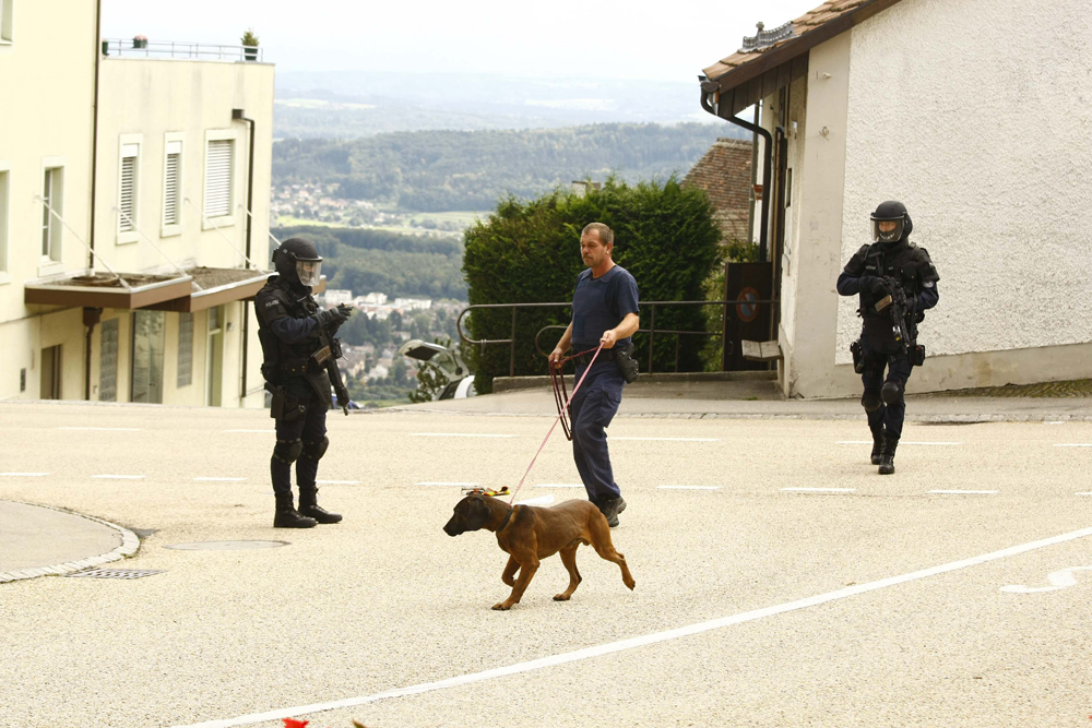 FOTO: PETER GERBER, 04.02.2010, Leublingen (BE):
Unterhalb von Magglingen im Dorf Leublingen sperrte die Sondereinheit der Polizei kurz die Strasse, zwei Schwerbew. beschtzten einen Bluthund der Polizei und dessen Fhrer, der Hund schnupperte in einer Tte und suchte die Spur vom Amok Senior aus Biel. Amok Biel